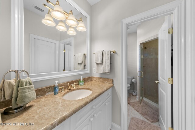 bathroom featuring tile patterned flooring, vanity, toilet, and walk in shower