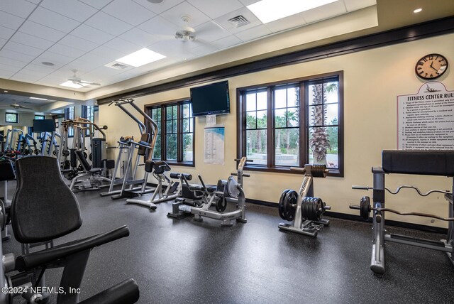 gym with ceiling fan and a drop ceiling