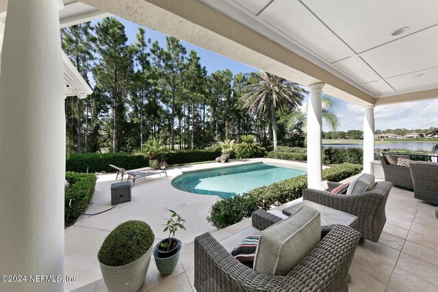 view of pool with a water view, an outdoor living space, and a patio area