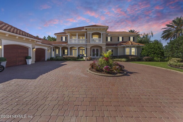 mediterranean / spanish-style home with a garage and a balcony