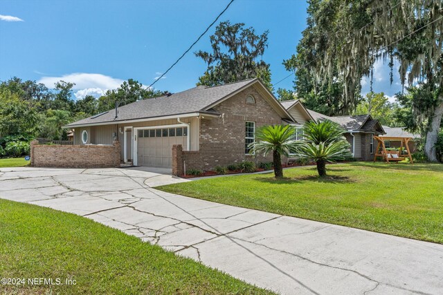 ranch-style home with a garage and a front lawn