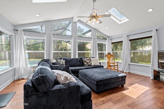 sunroom featuring ceiling fan, plenty of natural light, and lofted ceiling with skylight