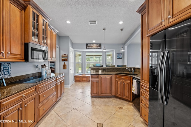 kitchen with a peninsula, a sink, visible vents, brown cabinets, and black appliances