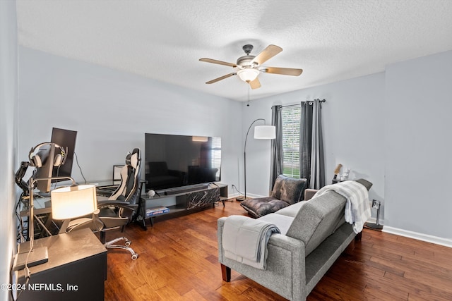 living room featuring a textured ceiling, dark wood-type flooring, and ceiling fan