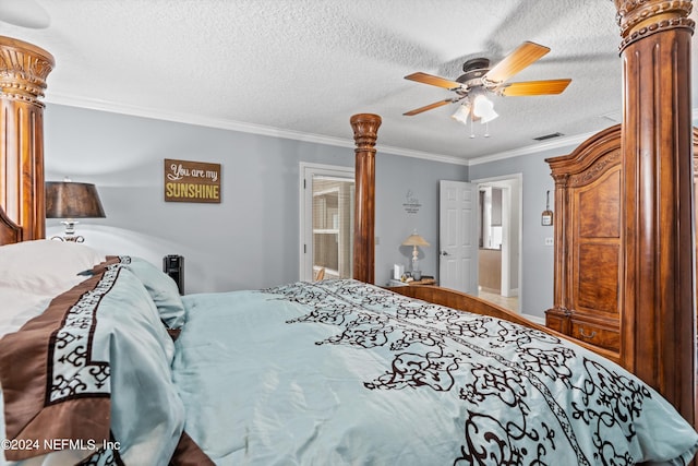 bedroom with ornamental molding, visible vents, a textured ceiling, and ornate columns