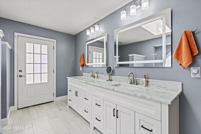 bathroom with vanity, tile patterned floors, and a skylight