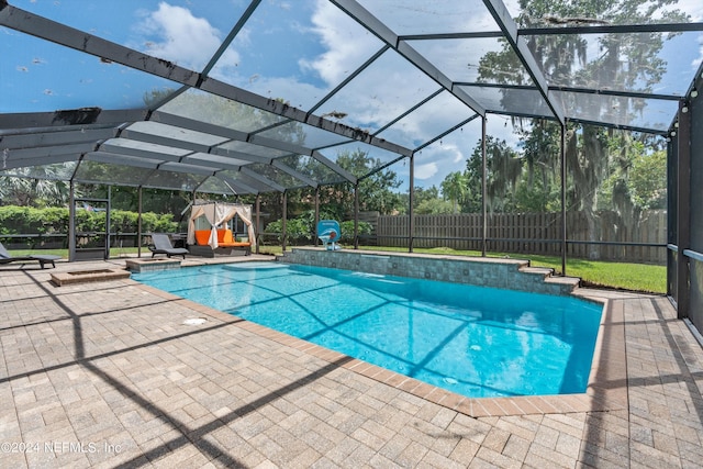 view of pool with a fenced in pool, glass enclosure, a fenced backyard, and a patio