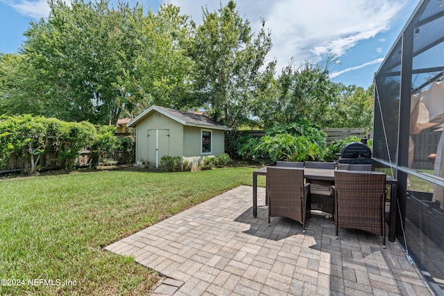 view of patio / terrace featuring an outbuilding, a lanai, a fenced backyard, and outdoor dining area