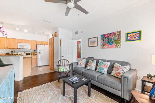 living room featuring ornamental molding, ceiling fan, and light hardwood / wood-style floors