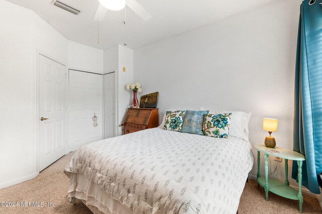 carpeted bedroom featuring ceiling fan and a closet