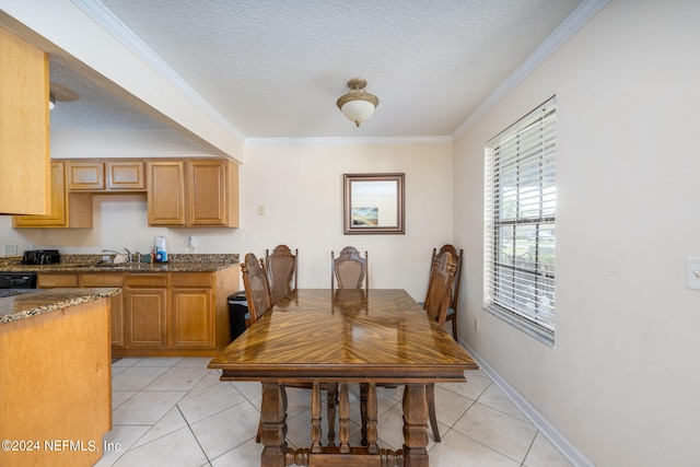 kitchen featuring a textured ceiling, crown molding, sink, and light tile patterned floors