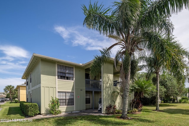 view of front of home featuring a balcony and a front yard