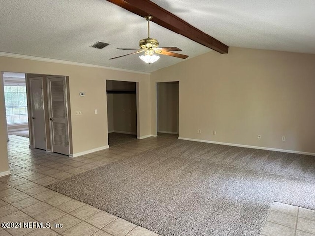 spare room featuring a textured ceiling, ceiling fan, light tile patterned flooring, and vaulted ceiling with beams