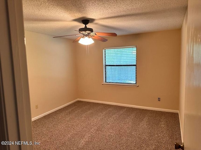 carpeted empty room with ceiling fan and a textured ceiling