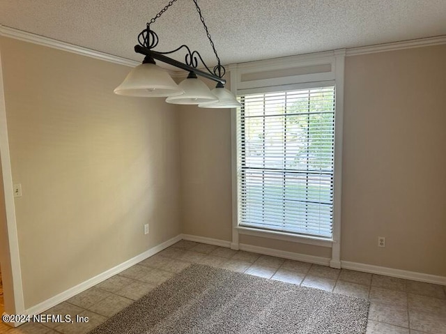 tiled spare room with a textured ceiling and ornamental molding