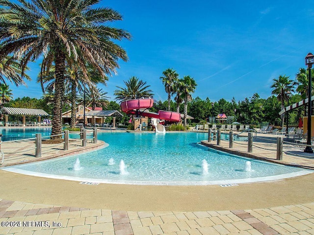 view of pool with a water slide and pool water feature