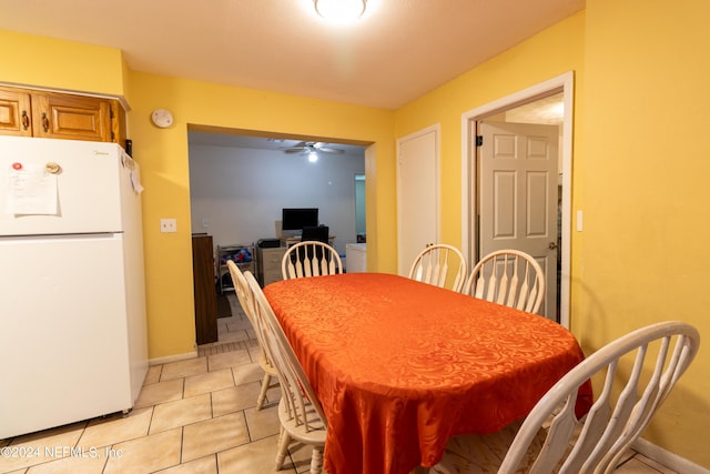 dining space with light tile patterned floors, baseboards, and ceiling fan