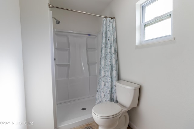 bathroom featuring curtained shower and toilet