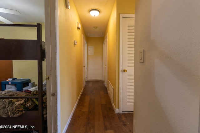 hall featuring dark wood-type flooring and baseboards