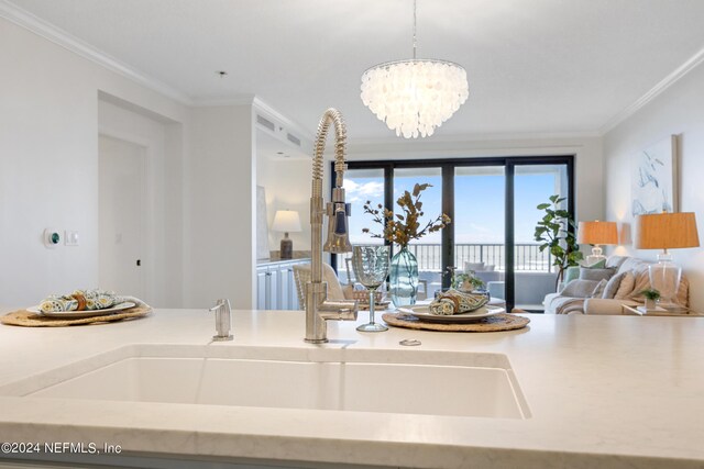 interior space with an inviting chandelier, crown molding, and sink