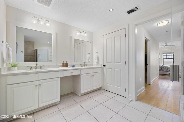 bathroom with ceiling fan, hardwood / wood-style flooring, a textured ceiling, and vanity