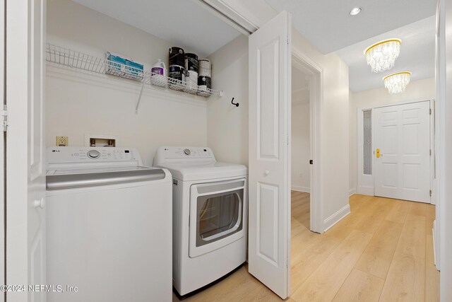 laundry room with separate washer and dryer, an inviting chandelier, and light hardwood / wood-style flooring