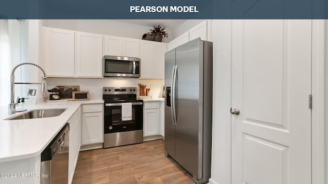 kitchen featuring white cabinets, light wood-style floors, stainless steel appliances, and a sink