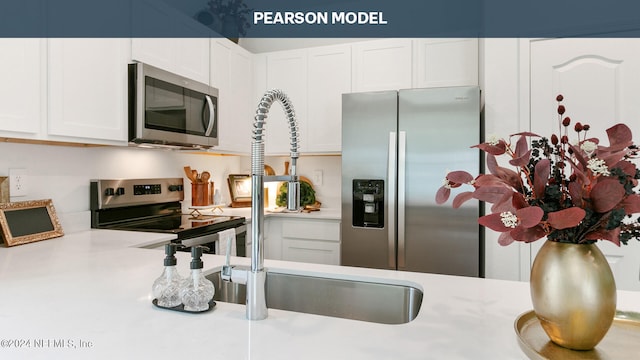 kitchen with white cabinetry, appliances with stainless steel finishes, and light countertops