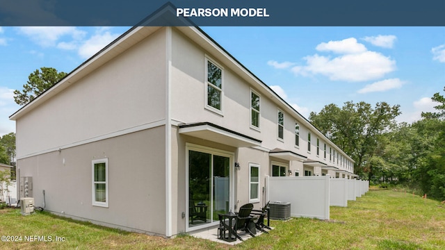 rear view of house featuring a patio, cooling unit, fence, a yard, and stucco siding