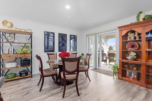 dining space with light hardwood / wood-style floors and crown molding