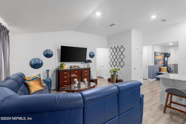 living room with light wood-type flooring, crown molding, a textured ceiling, and vaulted ceiling