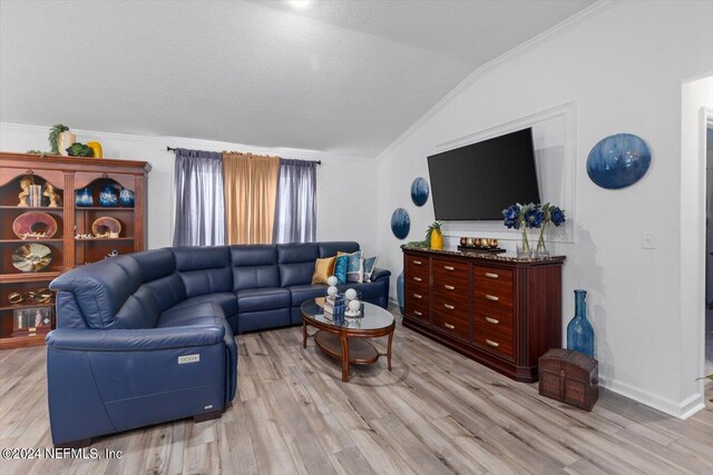 living room featuring light wood-type flooring, lofted ceiling, and ornamental molding