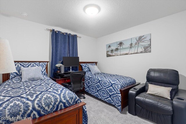 bedroom featuring light carpet and a textured ceiling