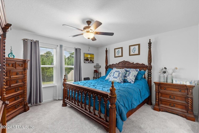 bedroom featuring a textured ceiling, ceiling fan, and carpet