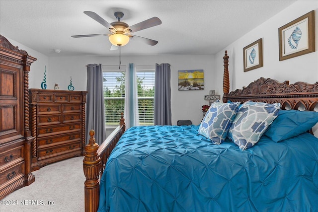 carpeted bedroom with a textured ceiling and ceiling fan