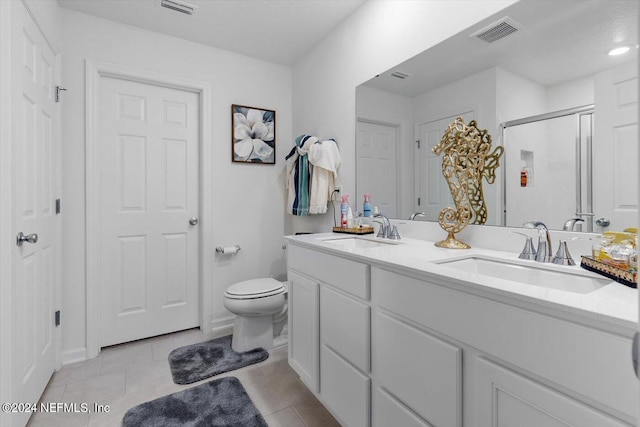 bathroom featuring vanity, toilet, tile patterned floors, and a shower with shower door