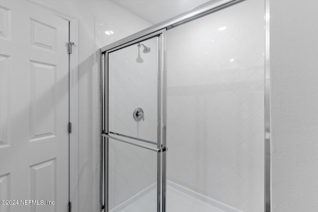 bathroom featuring a shower with shower door