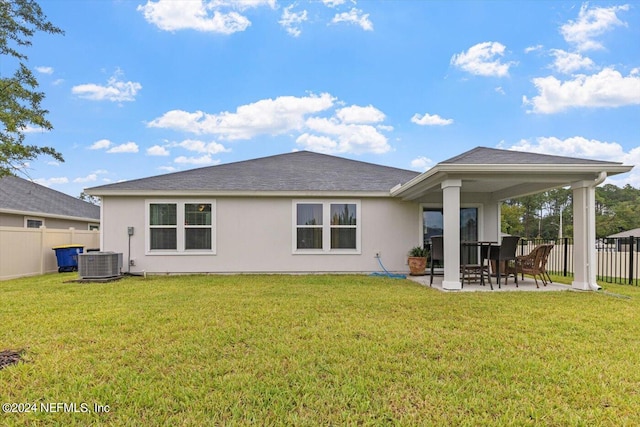 back of house featuring a patio area, a lawn, and central AC