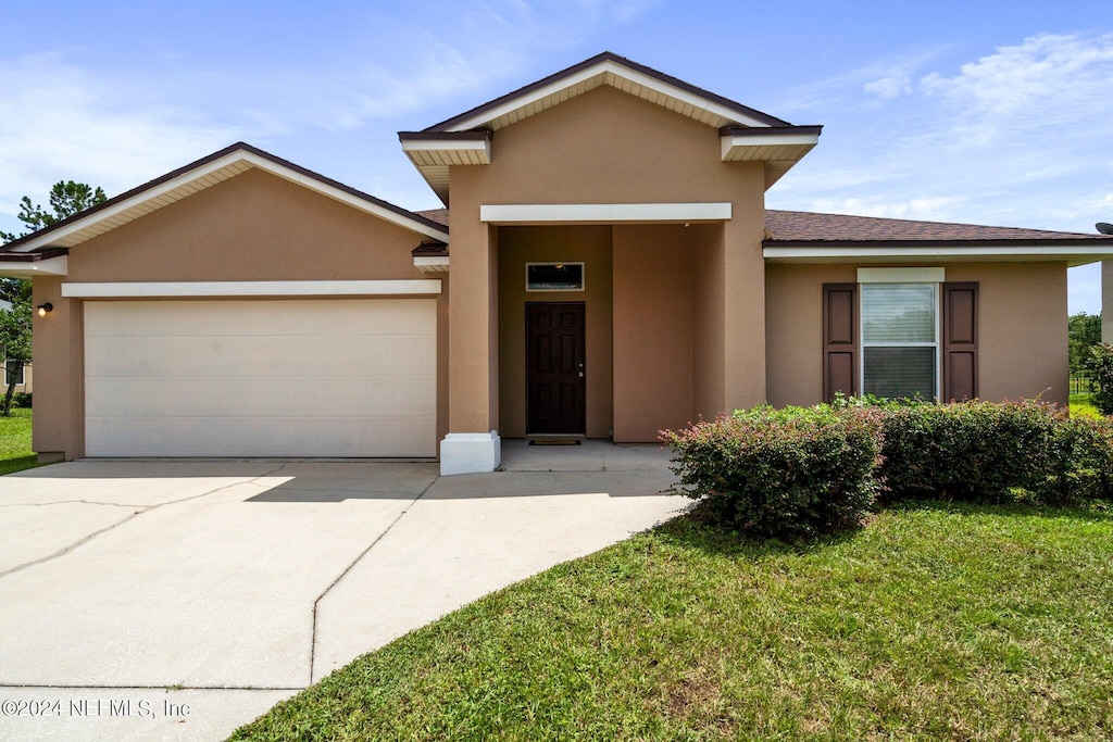 view of front of house featuring a garage and a front lawn