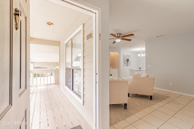 corridor featuring a chandelier, light wood-type flooring, visible vents, and baseboards