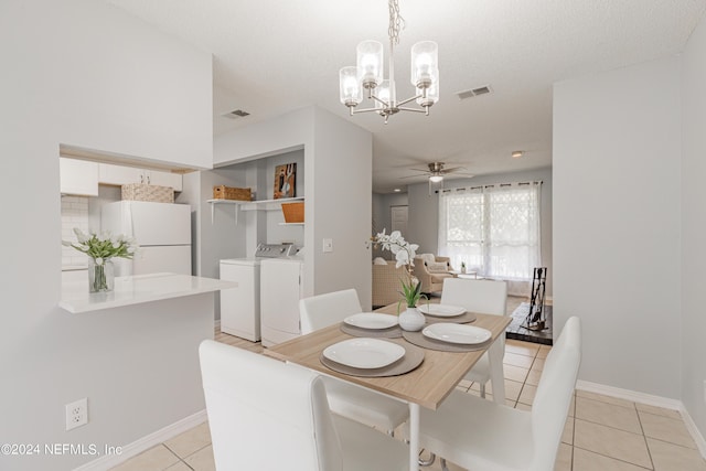 dining space with ceiling fan with notable chandelier, visible vents, washer and clothes dryer, and light tile patterned floors