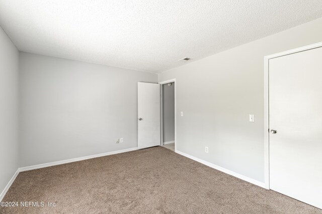 carpeted spare room featuring a textured ceiling