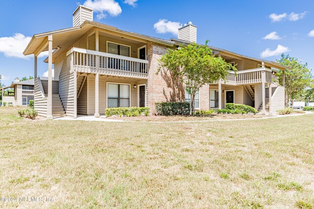 exterior space with a balcony and a yard