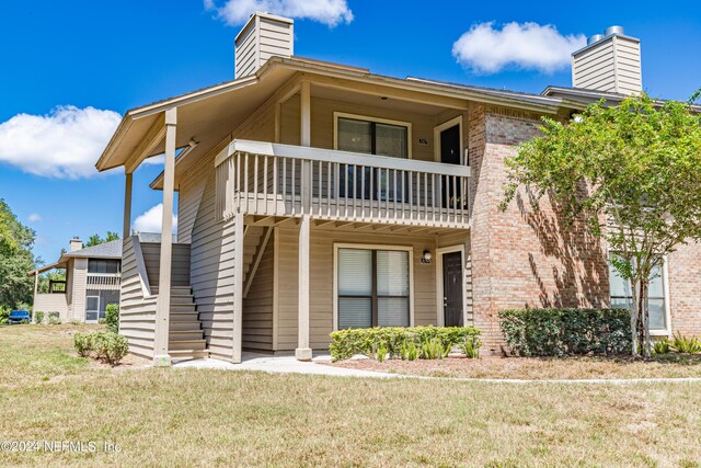 exterior space with a balcony and a front lawn