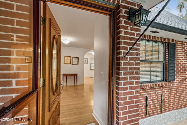 interior space featuring brick wall and light hardwood / wood-style floors