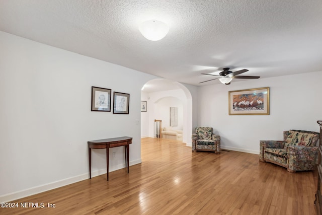 sitting room featuring ceiling fan, hardwood / wood-style flooring, and a textured ceiling