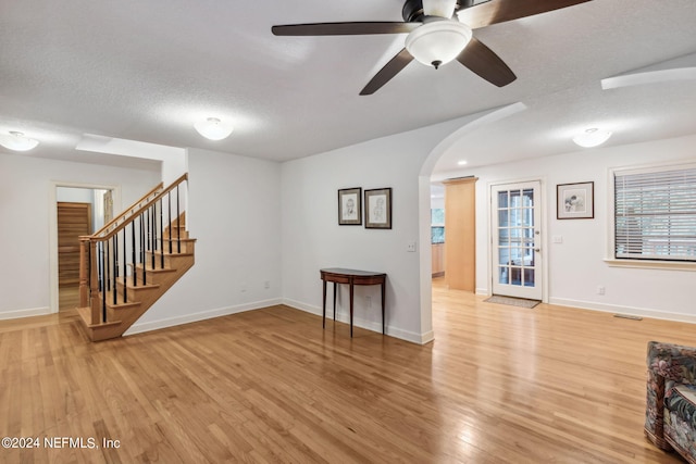 interior space with light wood-type flooring, a textured ceiling, and ceiling fan