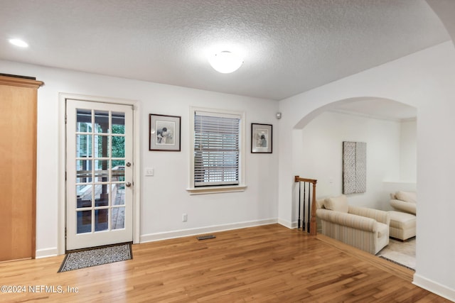 foyer with a textured ceiling and wood-type flooring