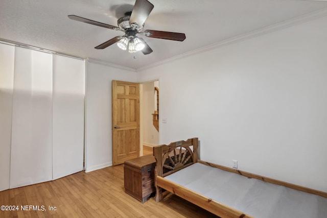 bedroom with crown molding, ceiling fan, and light hardwood / wood-style flooring