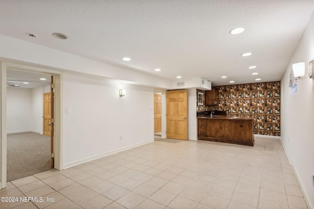 unfurnished living room featuring a textured ceiling and light tile patterned flooring